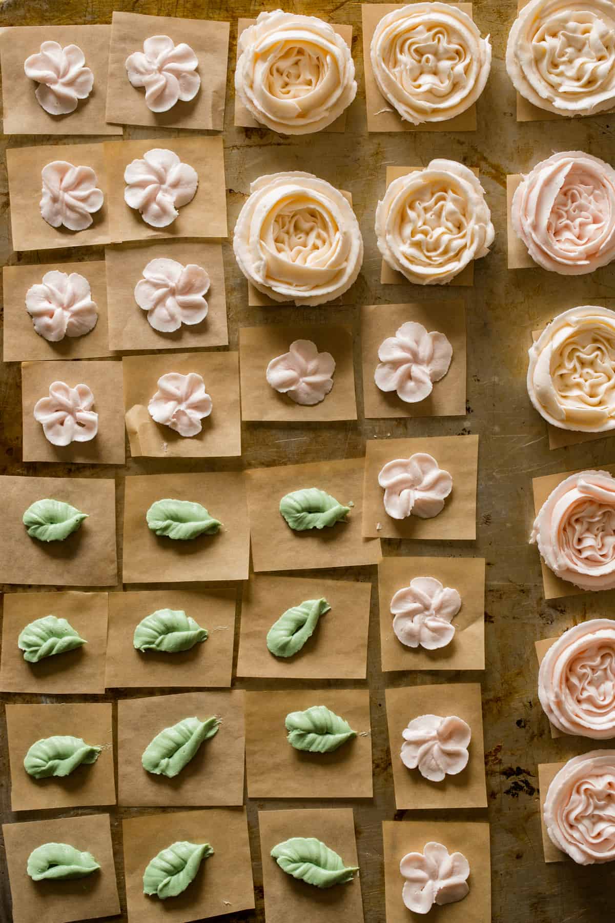 Floral buttercream decorations laid out for floral wreath cake.