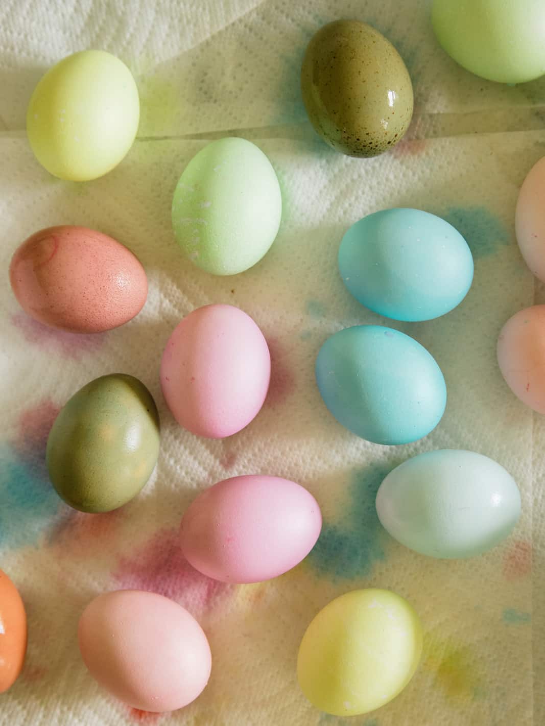 A close up of dyed Easter eggs in a variety of colors on paper towels.