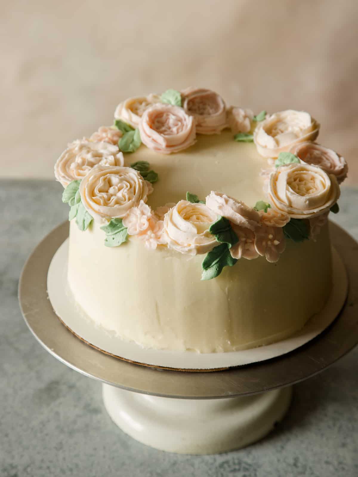 Floral wreath cake on a cake stand.