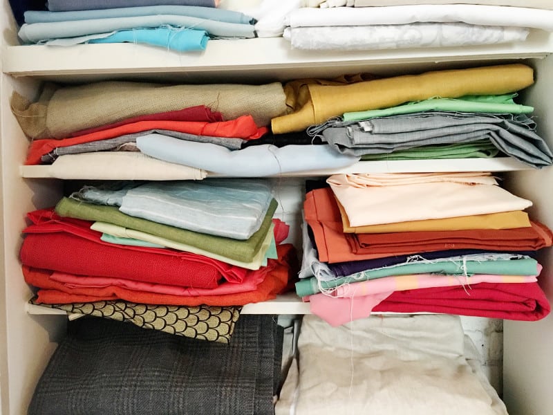 A close up of shelves of different colored linens.