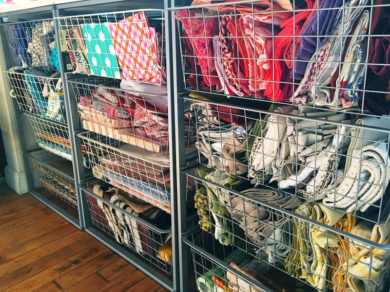 A close up of wire drawers full of a variety of colored napkins.