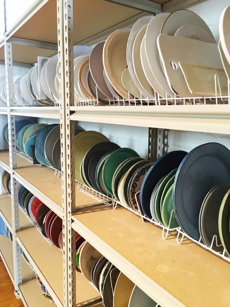 A close up of a variety of different colored and sized plates in plate racks.