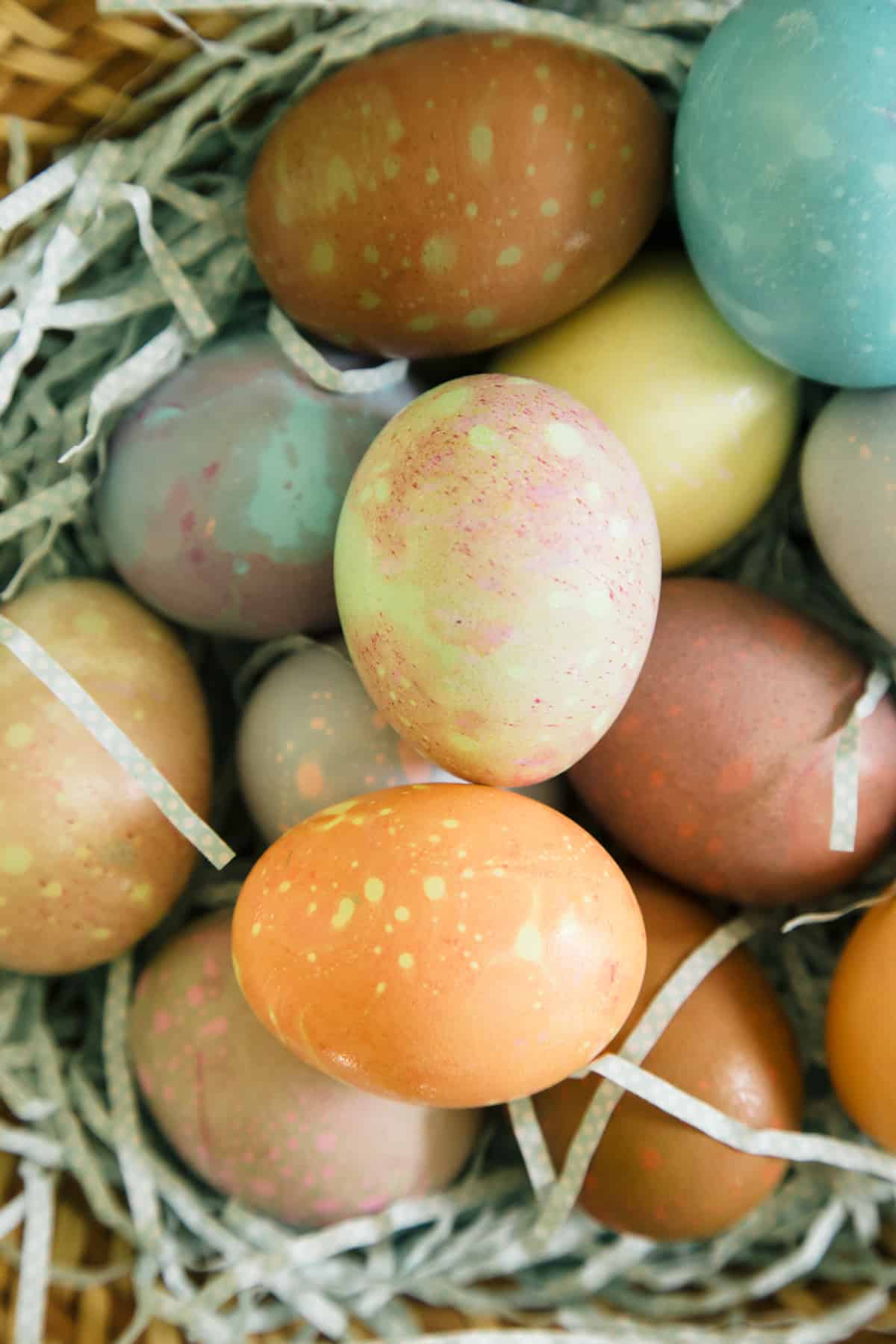 A close up of spotted Easter eggs on Easter grass.