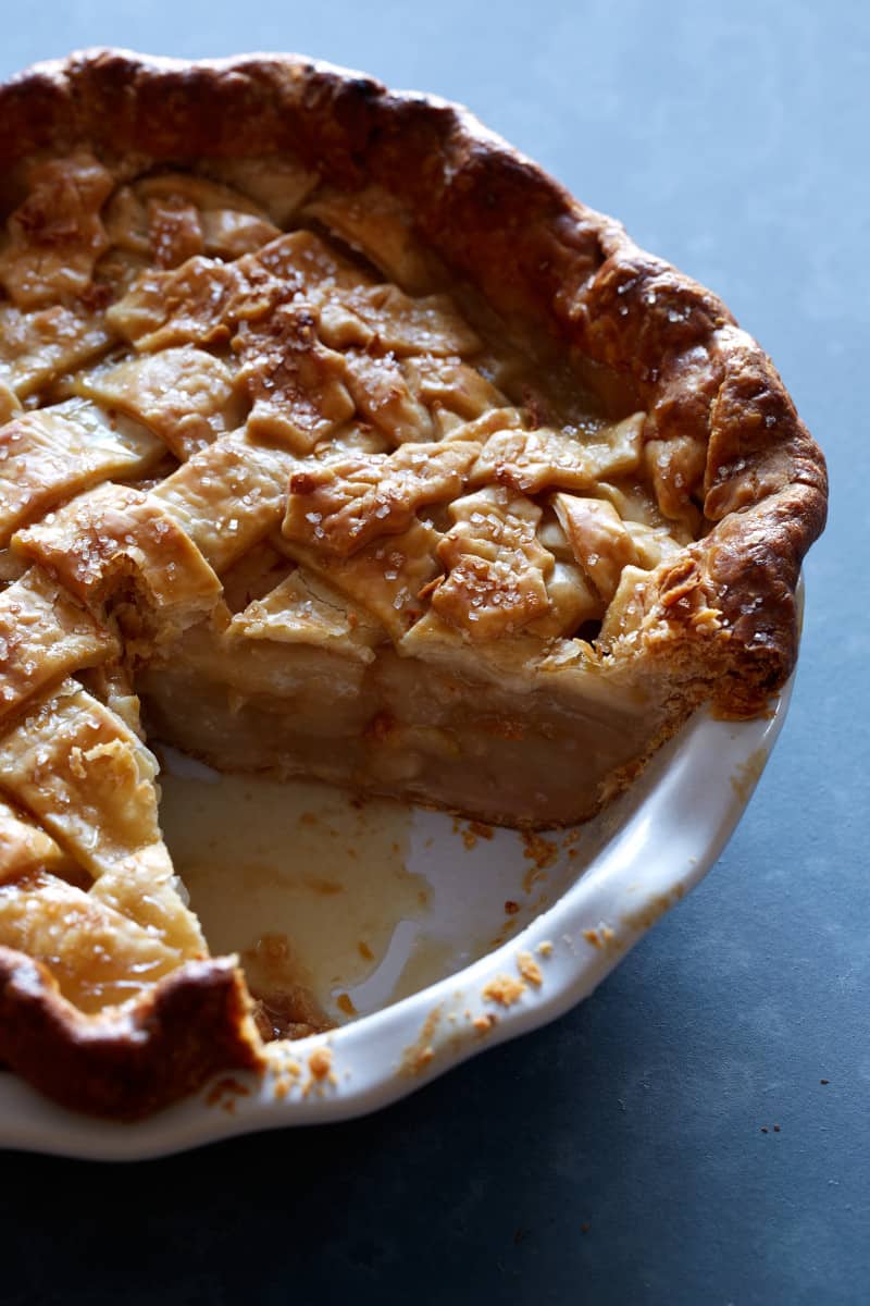 A close up of a maple, pear, ginger pie with a slice taken out.