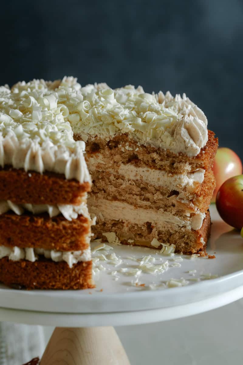 A close up of an apple cake with chai buttercream frosting with visible interior layers.