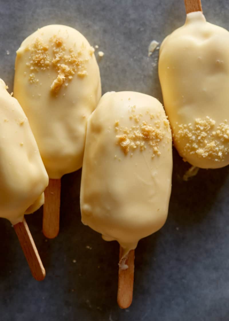 A close up of white chocolate dipped no bake strawberry cheesecake bars.