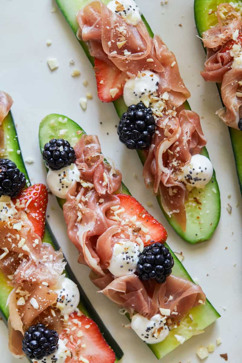 A close up of a plate of prosciutto cucumber crostini.