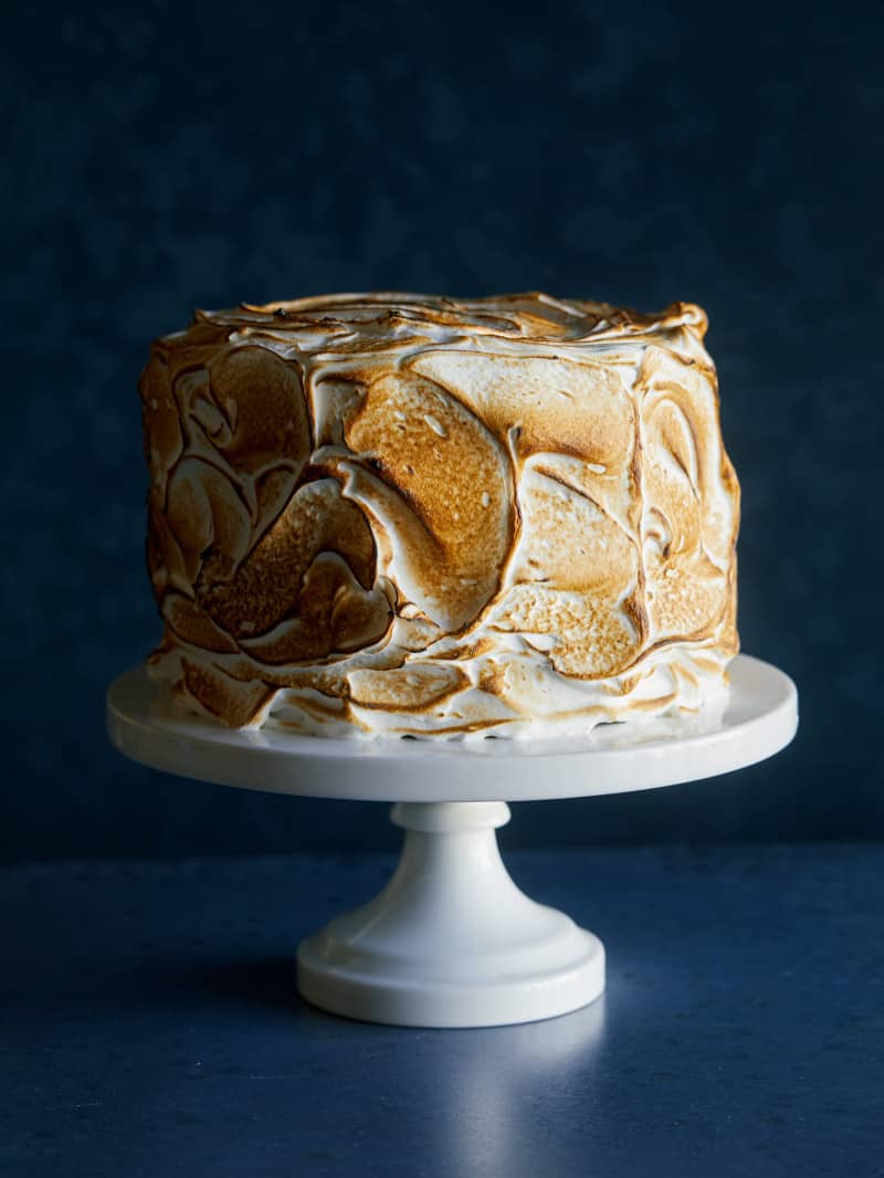 A six layer s\'mores cake on a white cake stand.