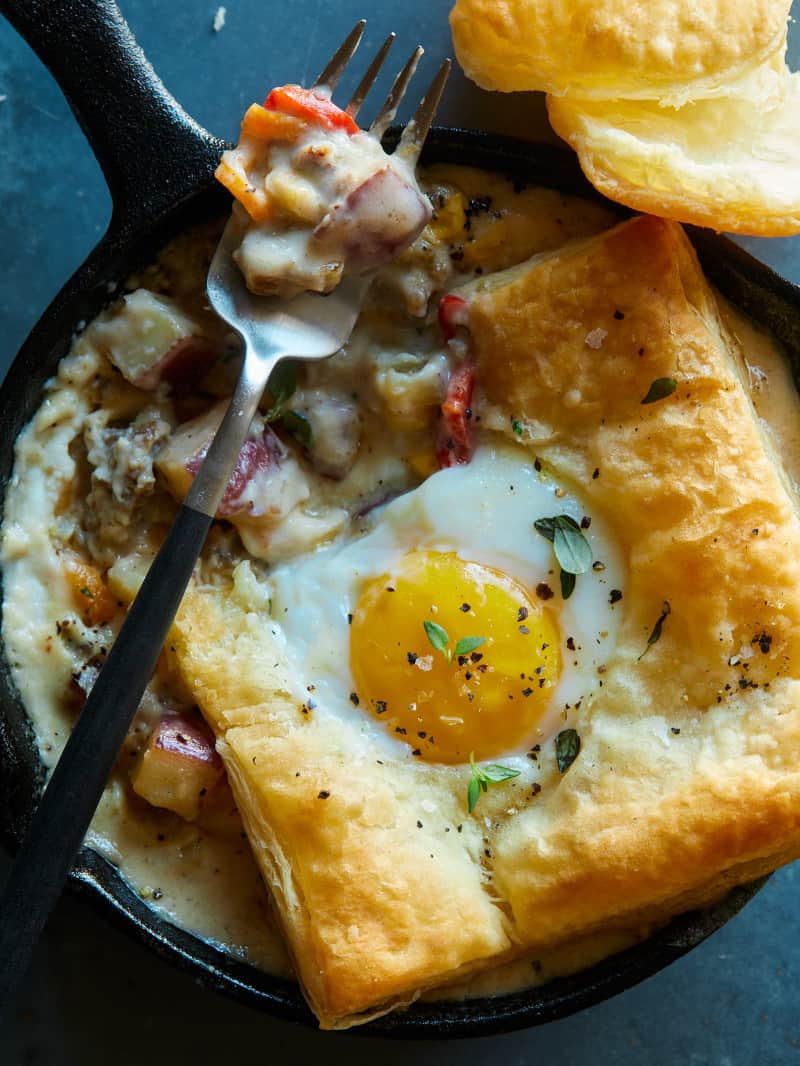A close up of a breakfast pot pie with a fork.