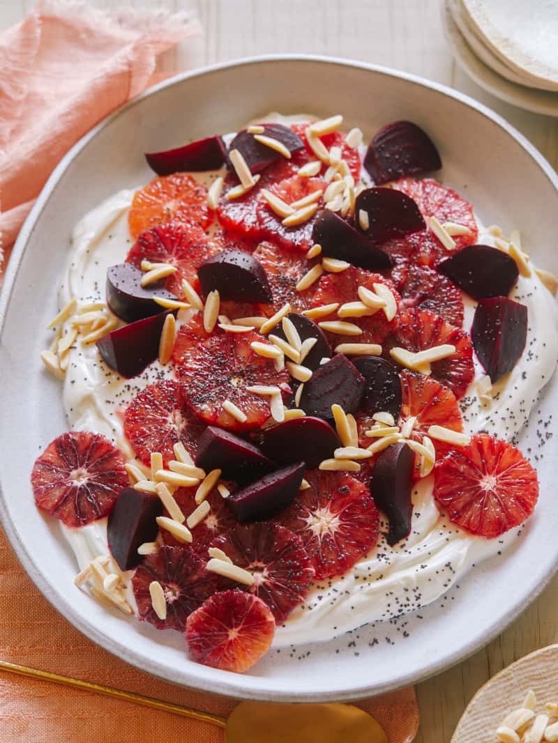 Blood orange and beet salad over honeyed yogurt in a bowl.