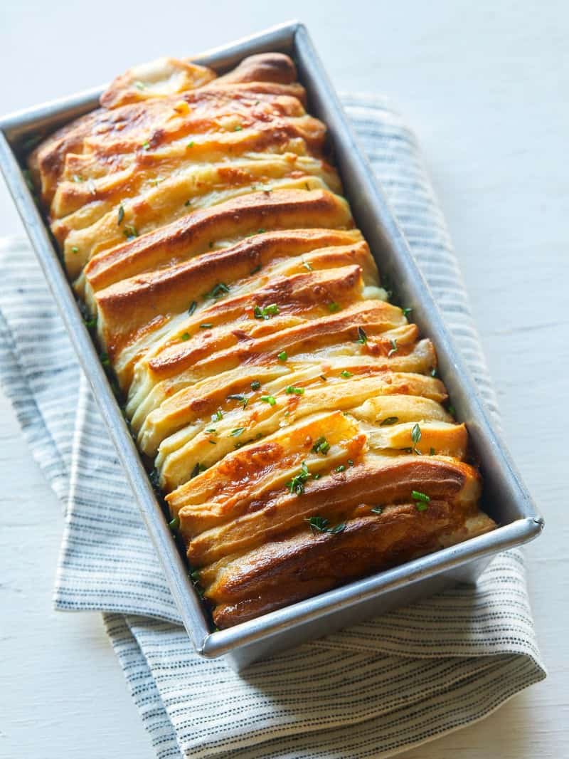 A close up of a pan of cheesy pull apart bread.