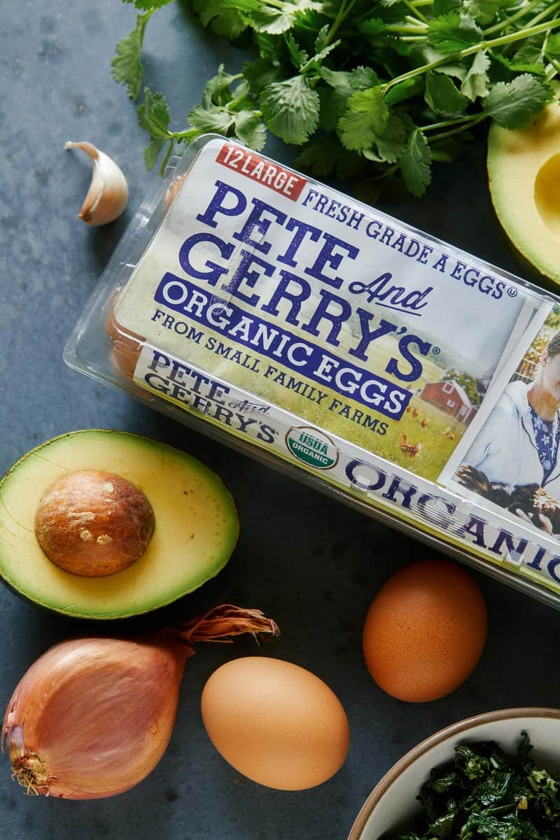 A package of Pete and Gerry\'s organic eggs with avocado and garlic cloves.