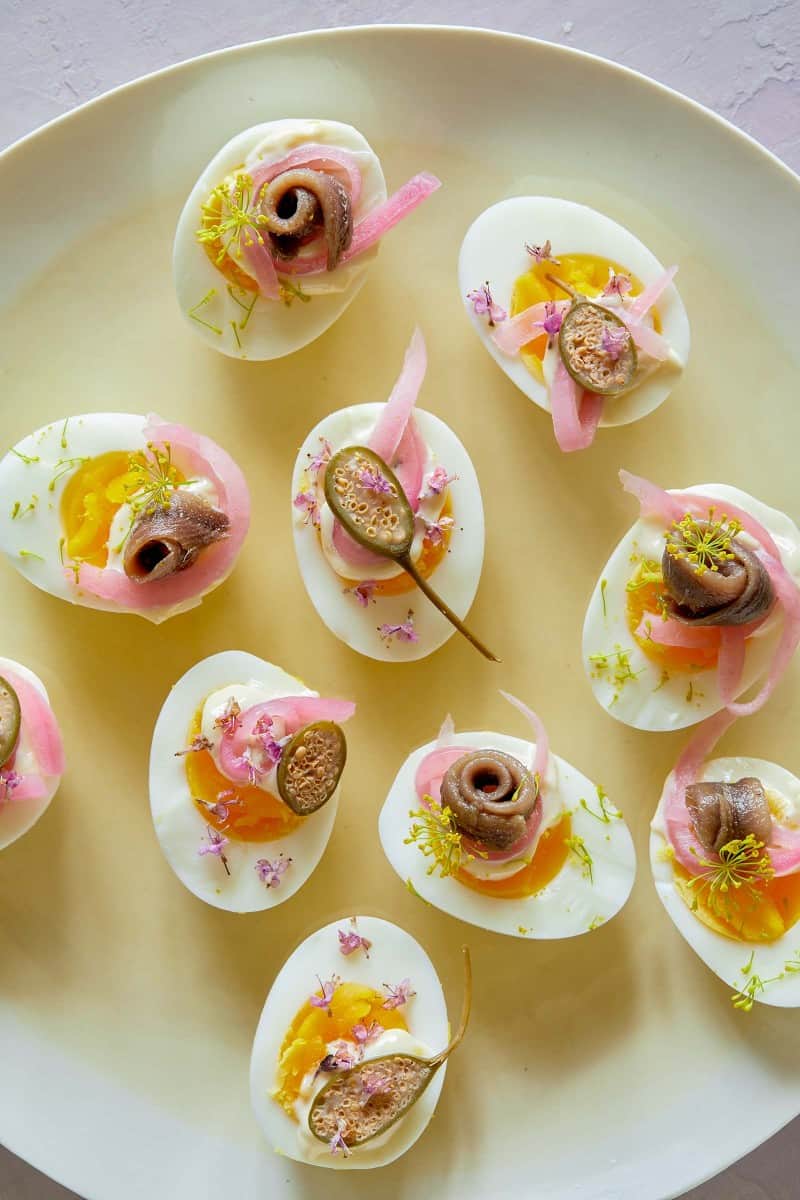 Undeviled eggs with caper berries, anchovies, and quick pickled red onion.