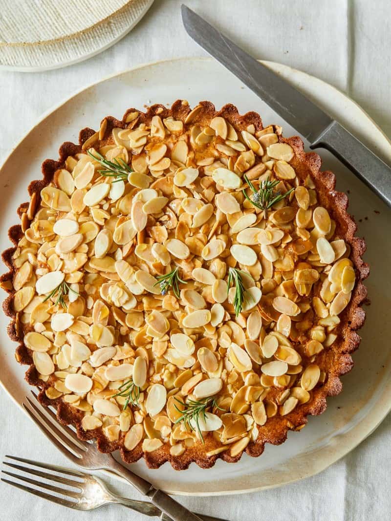 A whole almond and honey cornmeal cake with a knife.