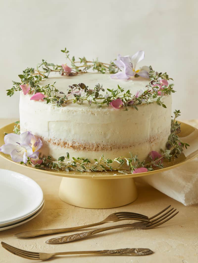 A browned butter cake with vanilla honey frosting, plates, and forks.