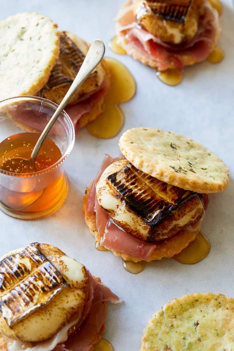 Savory smores of cheese, meat, and honey drizzled and on the side.