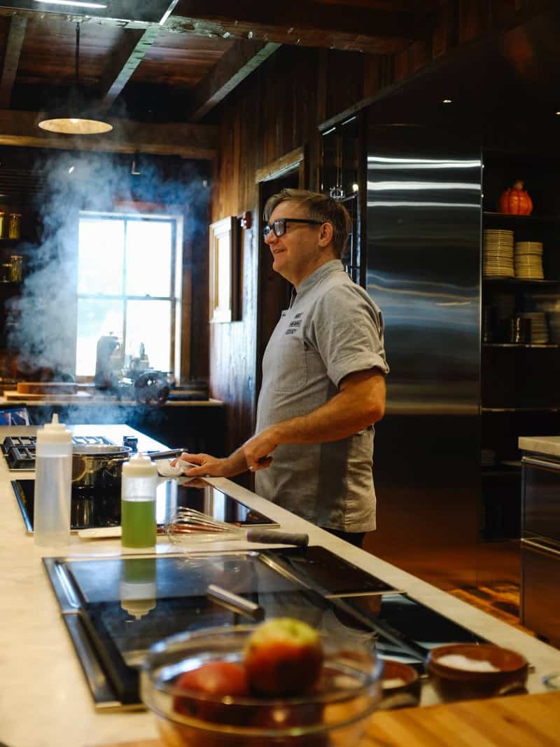 A man standing in a kitchen preparing food.