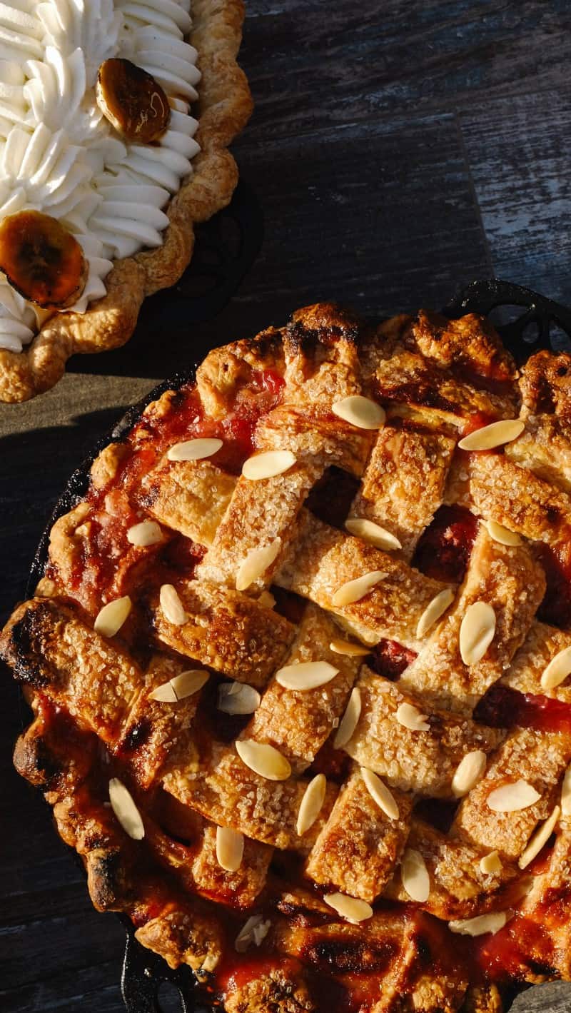 A close up of a lattice pie with sliced nuts.