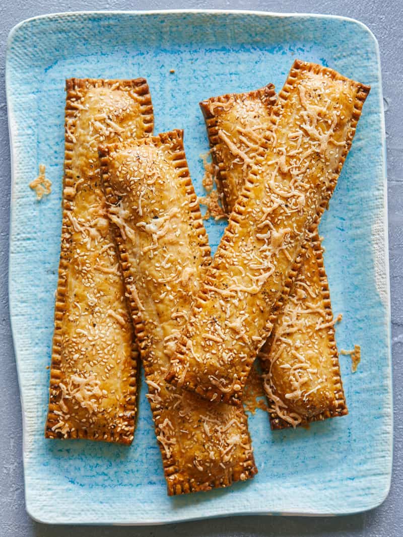 Creamy chicken and green onion hand pie sticks on a blue platter.