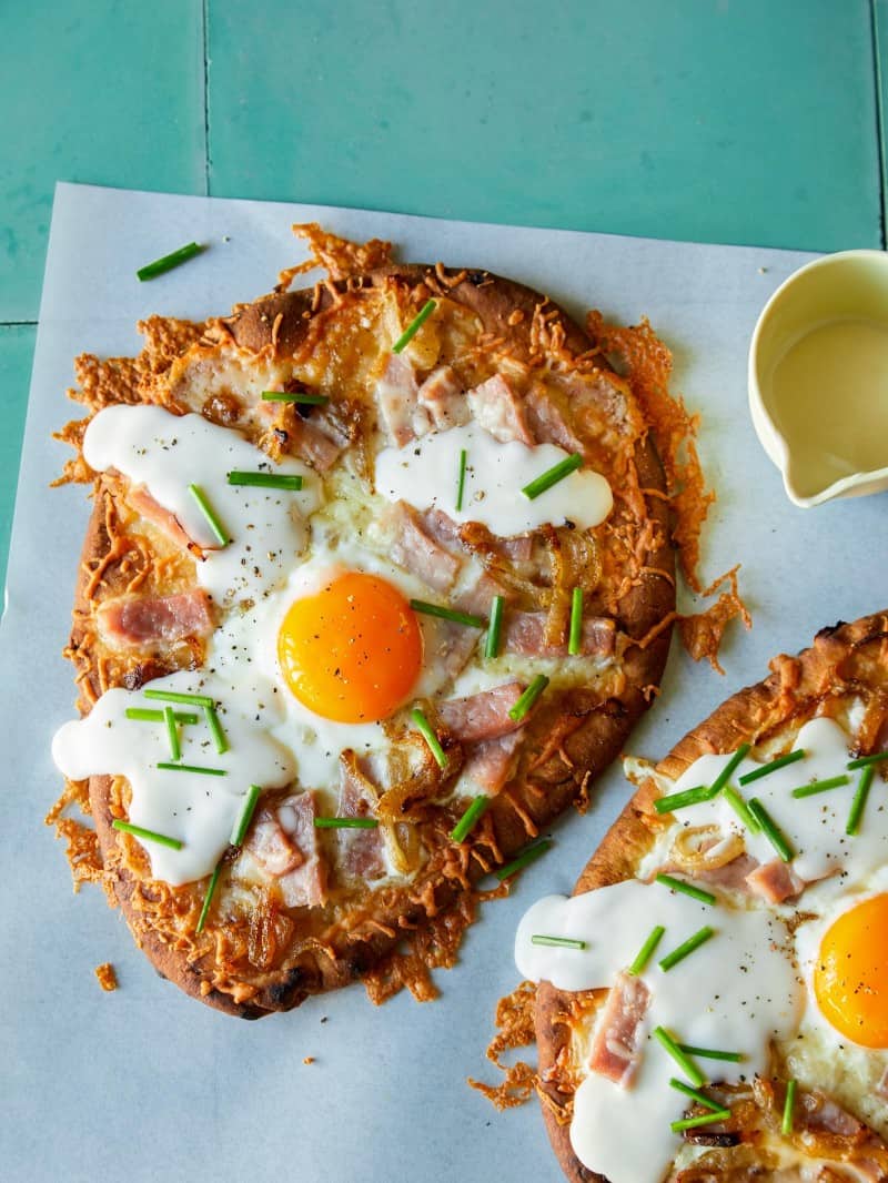 Croque madame flatbread, cut in half with a runny egg yolk.