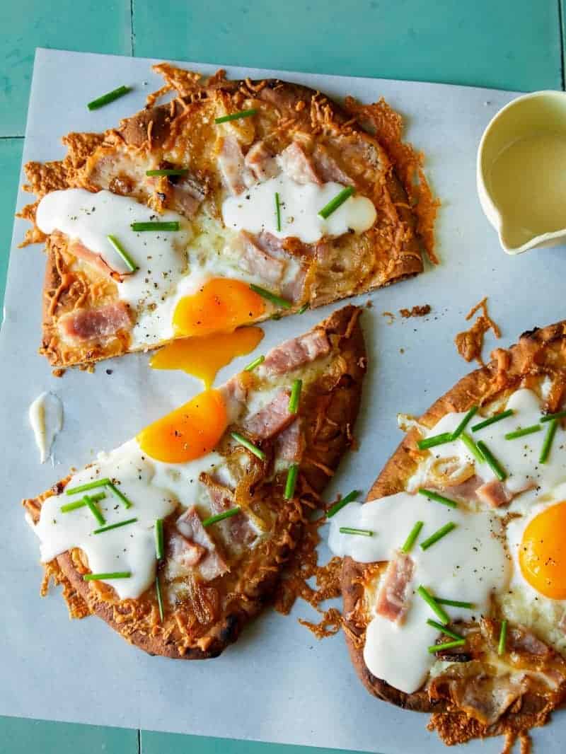 Croque madame flatbread, cut in half with a runny egg yolk.