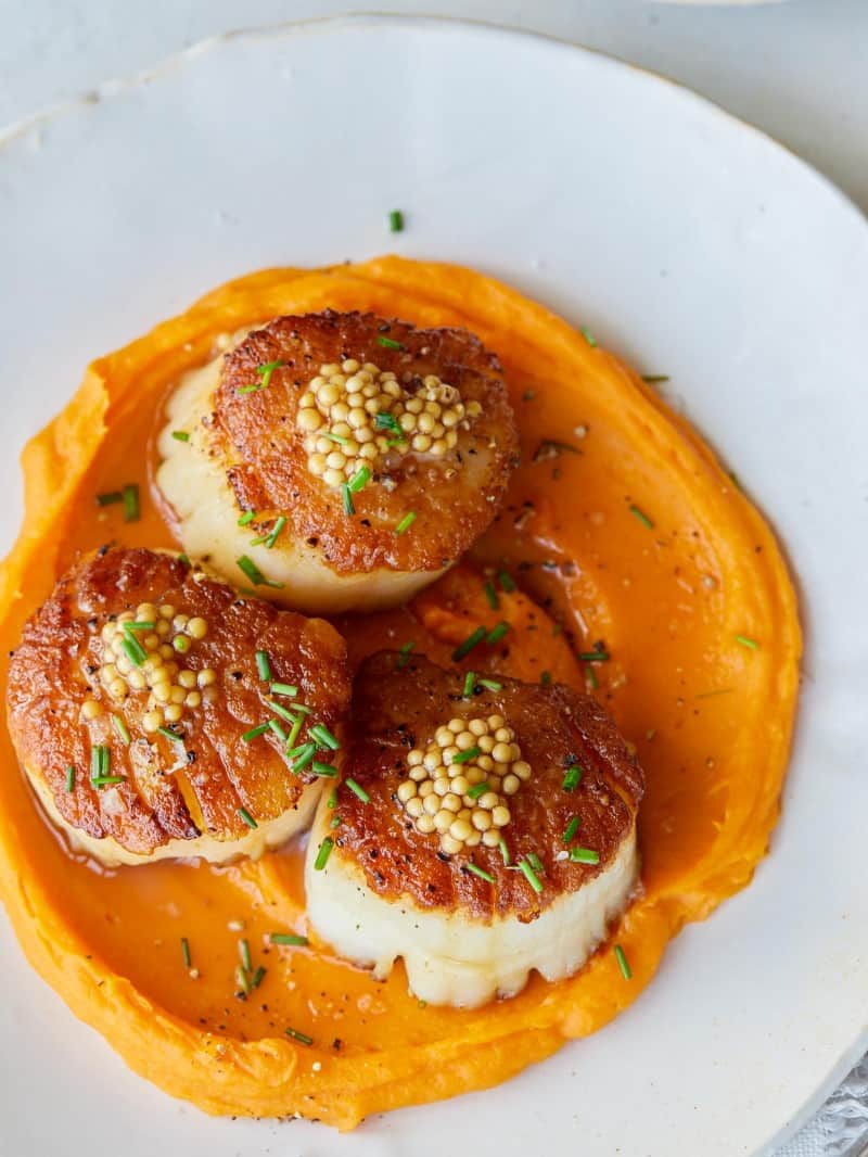 Seared scallops over roasted sweet potato pureee with pickled mustard seeds.