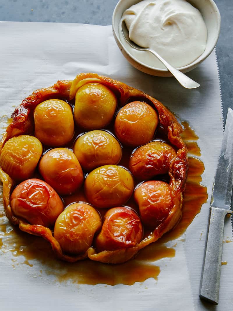 A whole honey crisp apple tart tatin with soft whipped cream on the side.