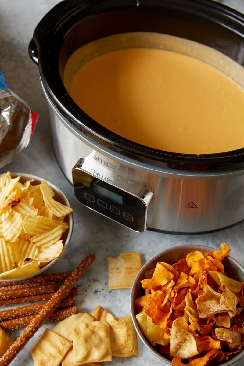 A crock pot of beer cheese with chips.