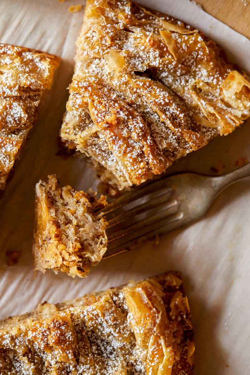 A close up of a slice of chai spiced ruffled milk pie with a fork.