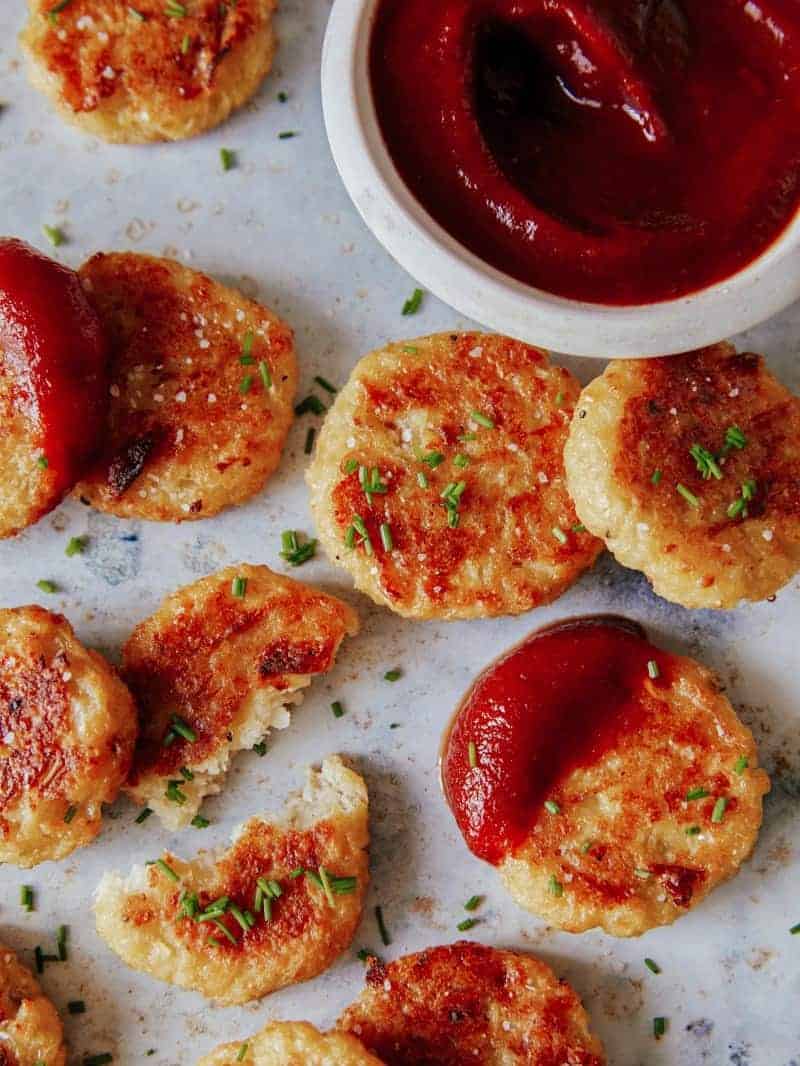 A close up of crispy baked cauliflower tots with sauce.