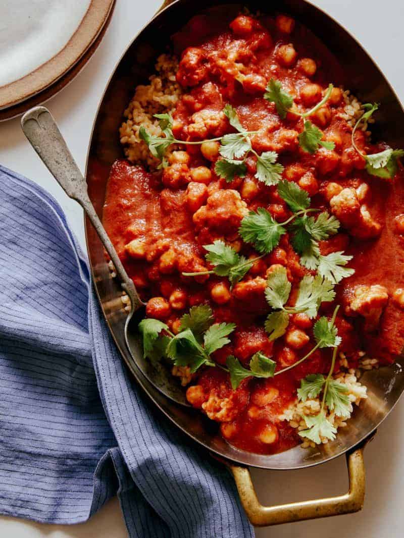 Spicy vegan chickpea and cauliflower curry with a spoon.