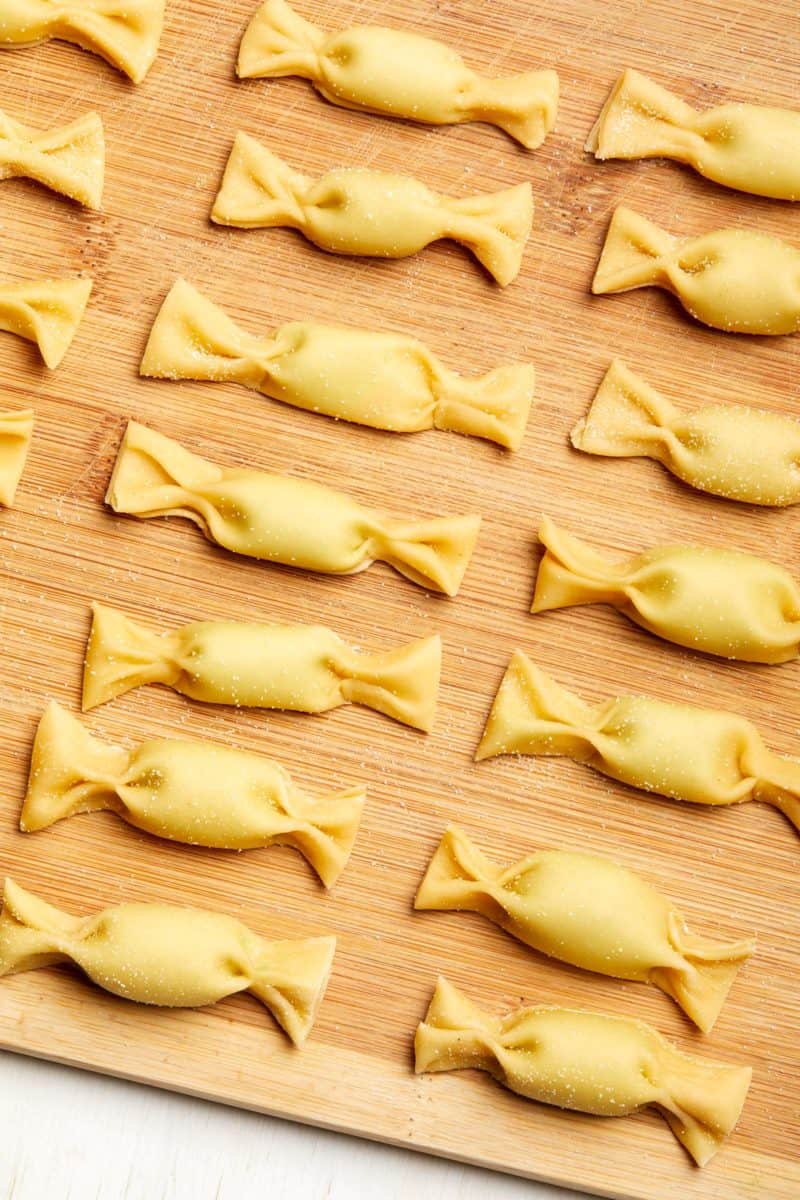 A close up of uncooked caramelle on a cutting board.