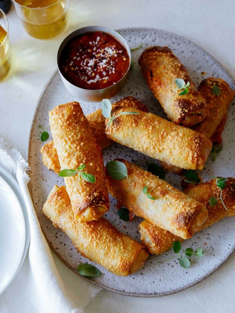 Crispy baked pepperoni pizza egg rolls with sauce on the side.