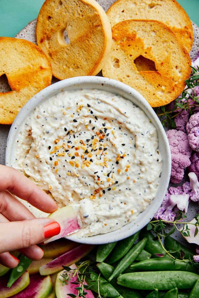 A close up of everything seasoning and caramelized onion dip with bagels. 