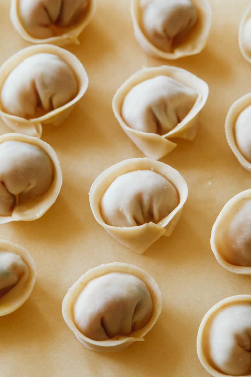 A close up of uncooked pork and shrimp dumplings.