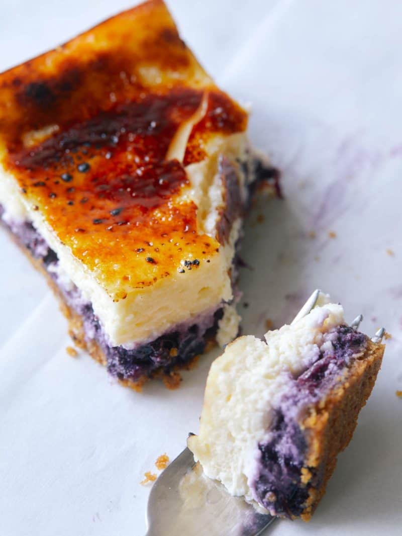 A close up on a Blueberry Cheesecake Crème Brûlée bar with a chunk taken out by a fork.