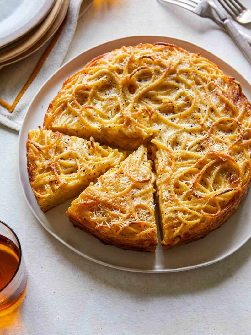 Cacio e pepe pasta pie with slices cut.