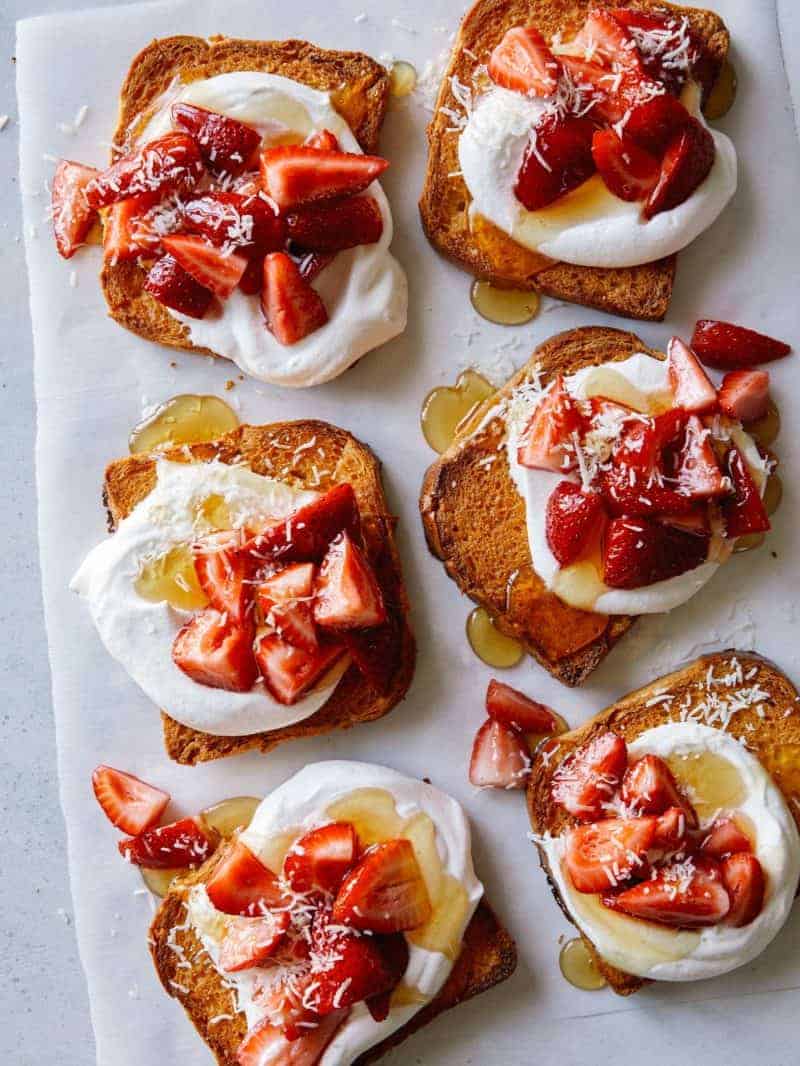 Honey brick toast topped with whipped cream and strawberries.