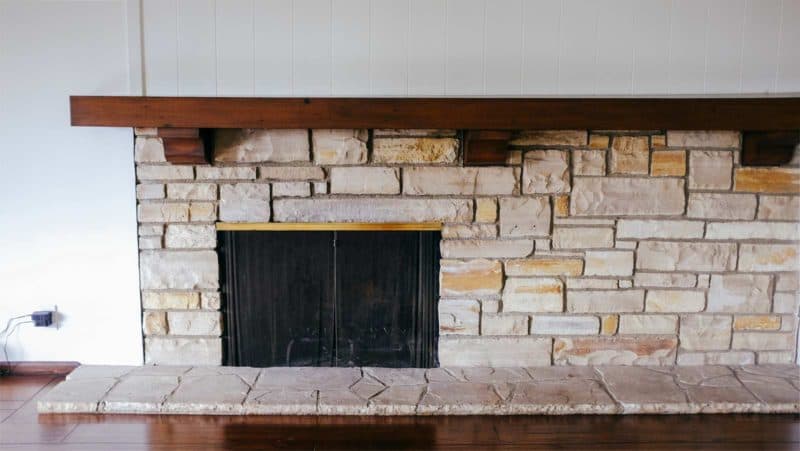 A stone fire place in a living room.