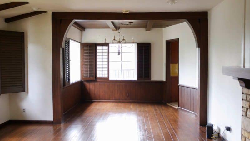 An empty dining room with wood accents and a light fixture.