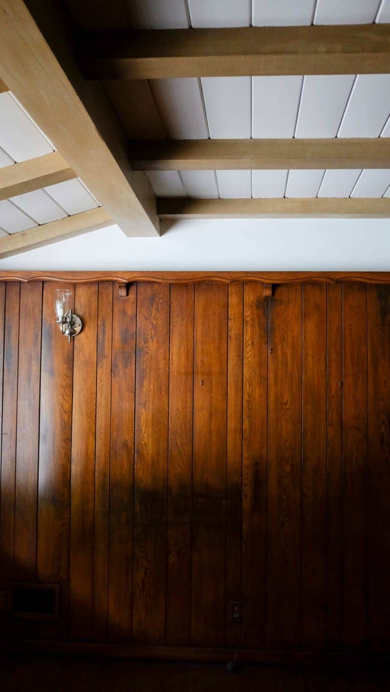 A wood paneled wall with a light fixture.