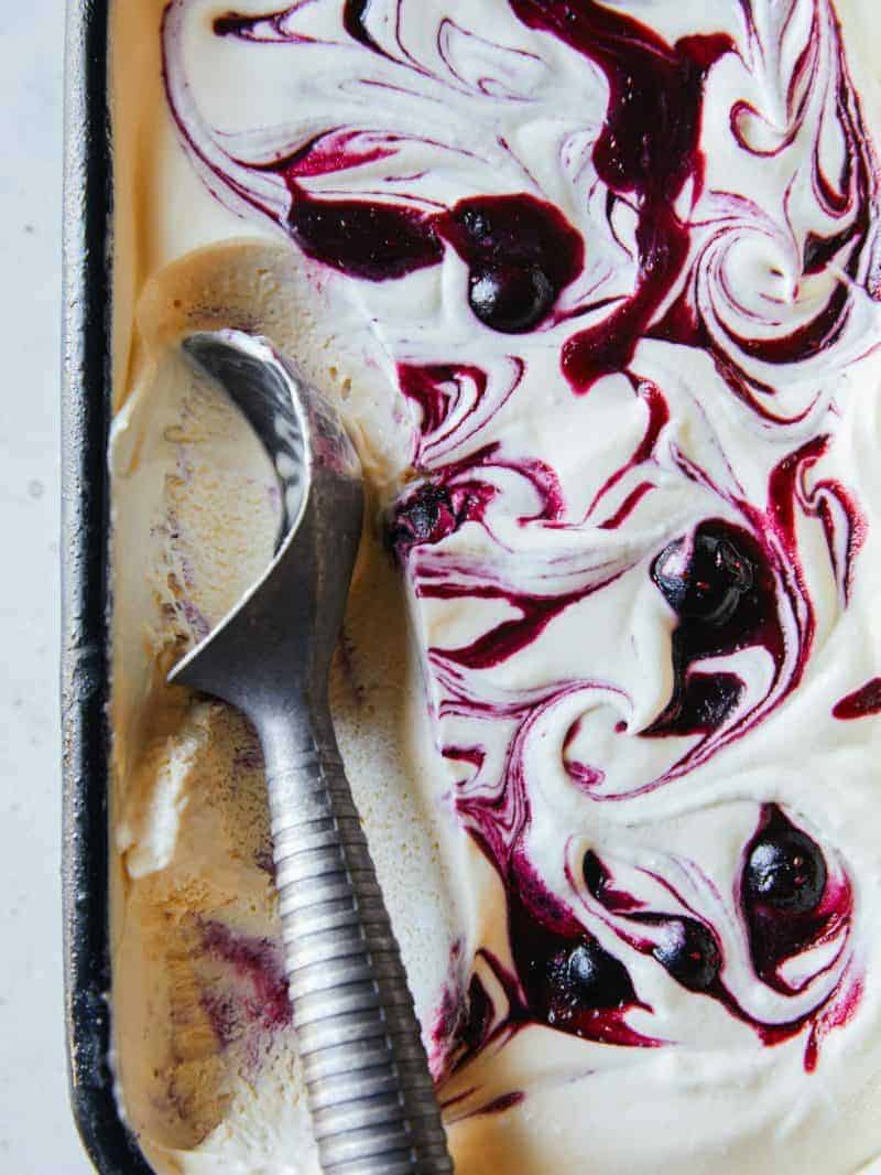 A close up of blueberry vanilla honey swirl semifreddo with ice cream scoop.