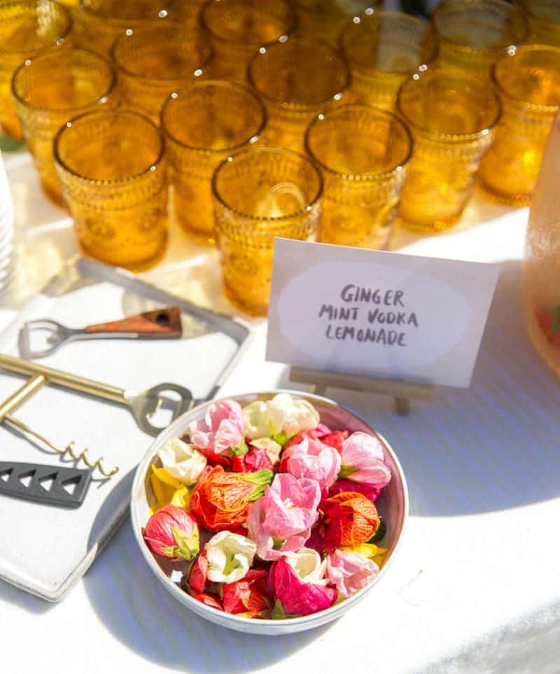 Drink glasses with floral garnish and small sign.