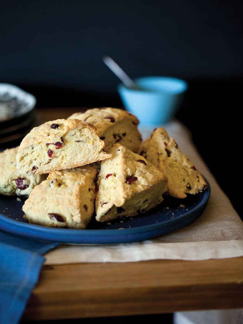 Cranberry and Orange Scone spread with butter.