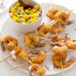 Coconut Shrimp skewers on a plate with mango salsa