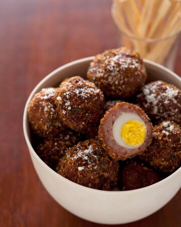 Hard boiled quail egg wrapped in sausage, coated in bread crumbs, then fried.