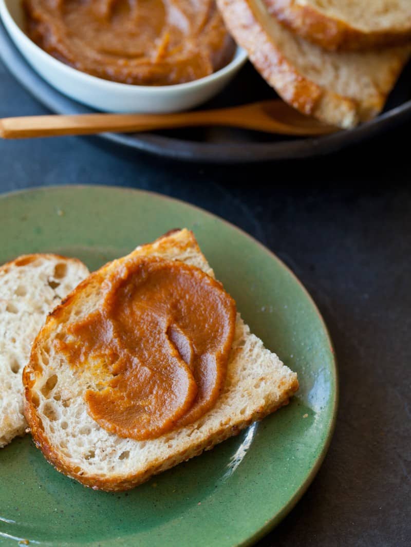 A close up of a plate of bread smeared with pumpkin butter.