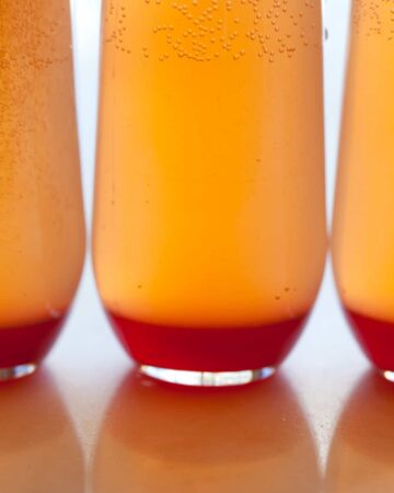 A close up of several spicy blood orange champagne punch in glasses.