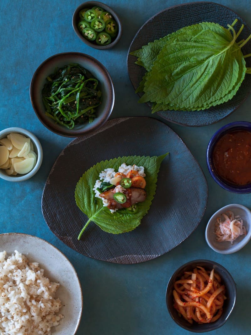 Ingredients in bowls and on plates and an assembled bo ssam bite.