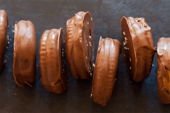 A close up of chocolate covered peanut butter Ritz sandwiches disappearing one by one gif.